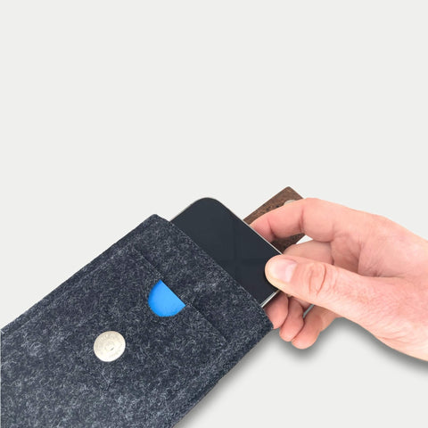 Das Samsung Galaxy A37 wird von Hand in eine stilvolle anthrazitfarbene Filztasche mit Kartenfach und Magnetverschluss gesteckt.