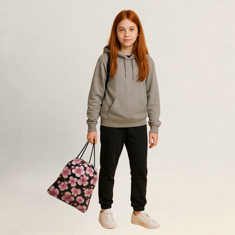 Person hält einen Turnbeutel mit Kirschblüten-Design locker in der Hand.