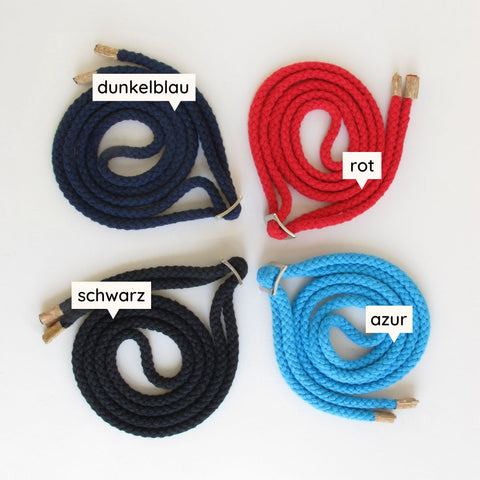 Diverse geflochtene Bänder in dunkelblau, rot, schwarz und azur für Taschen oder Accessoires, mit goldenen Enden.
