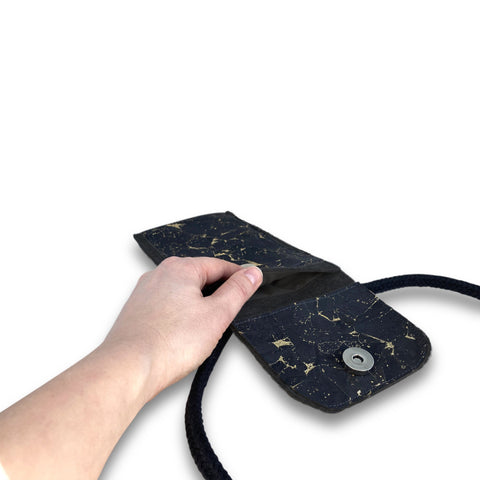 KEDJA deluxe Umhängetasche in anthrazit-schwarz mit Sicht auf das geöffnete Fach und Hand, ideal für iPhone 16 Pro Max